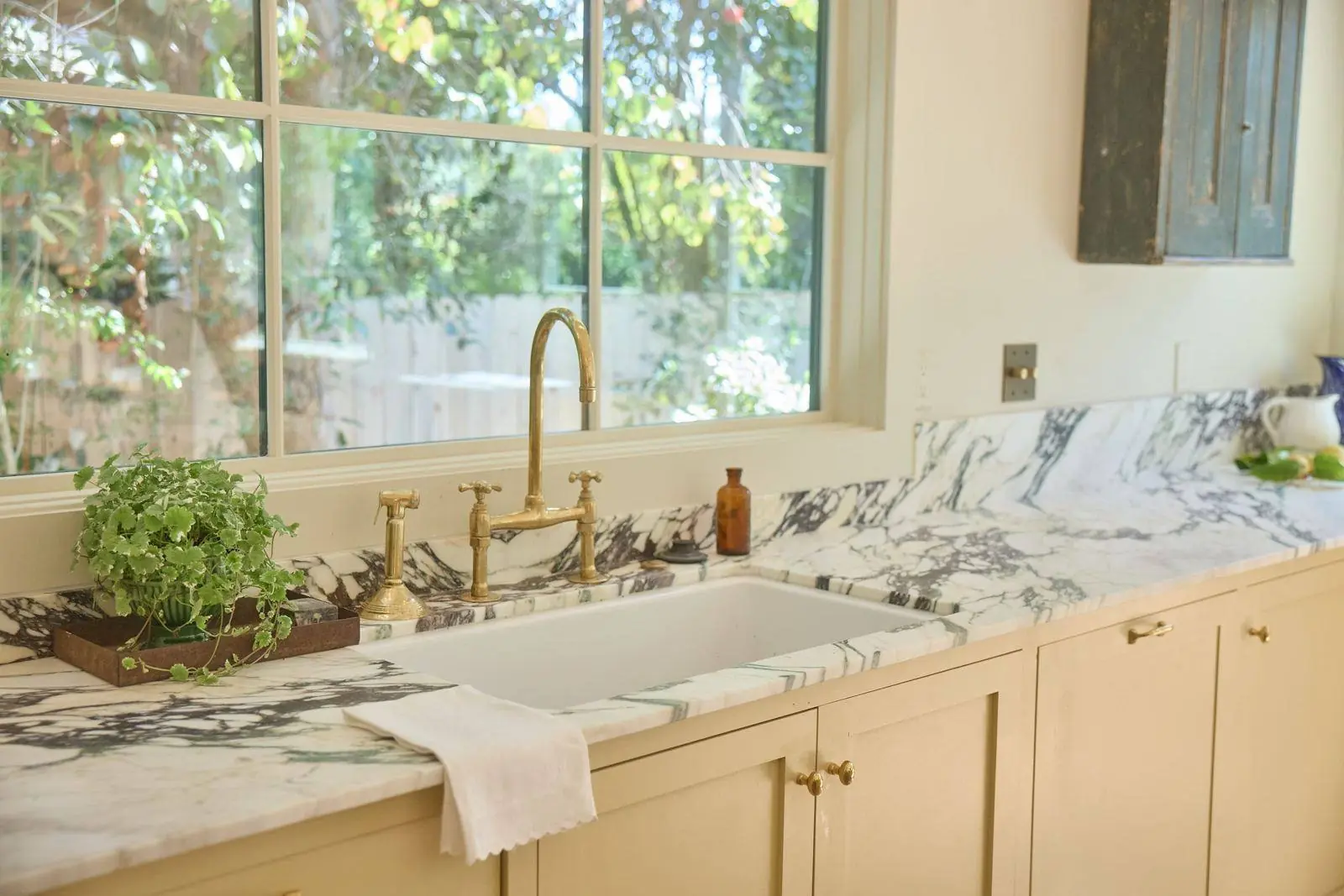 Painted inset cabinets under a marble counter
