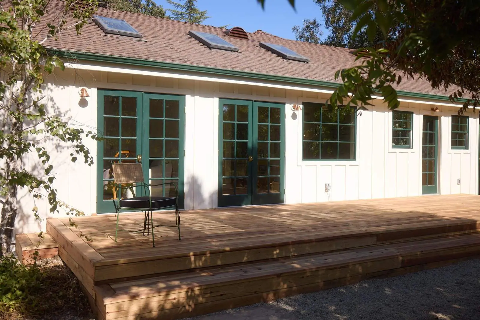 Board-and-batten cottage with green French doors and a wood deck, Ojai Gridley