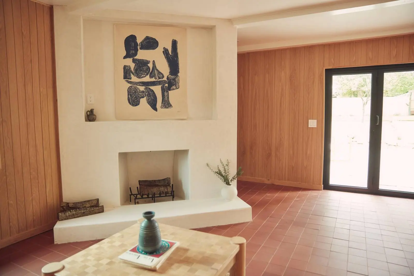 Plaster fireplace and white oak paneling beside glass doors, Ojai Woodland