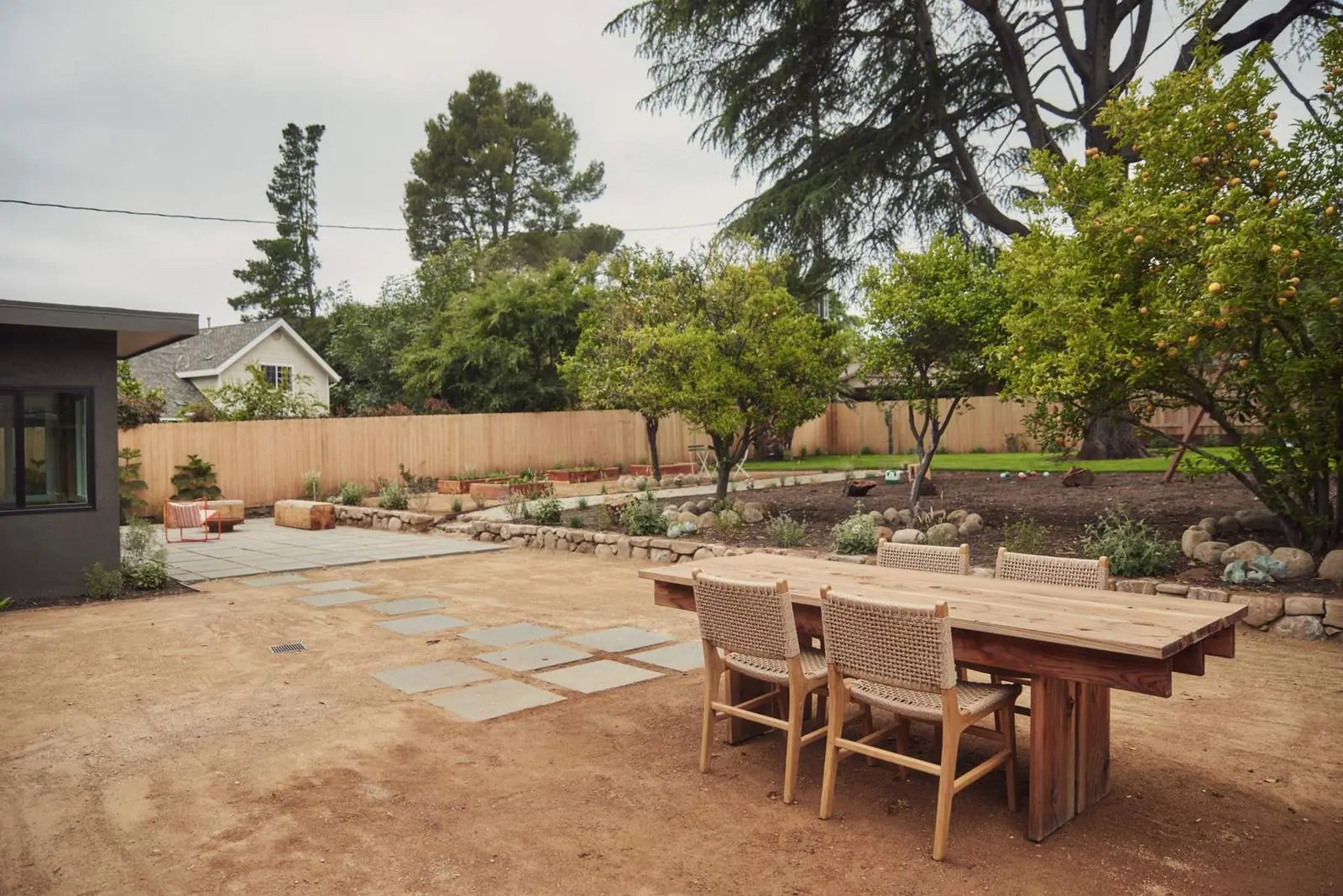 Backyard with an outdoor dining table and young trees, Ojai Woodland