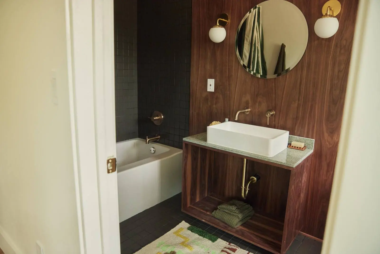 Bathroom with a vessel sink on a walnut vanity and a round mirror, Ojai Woodland