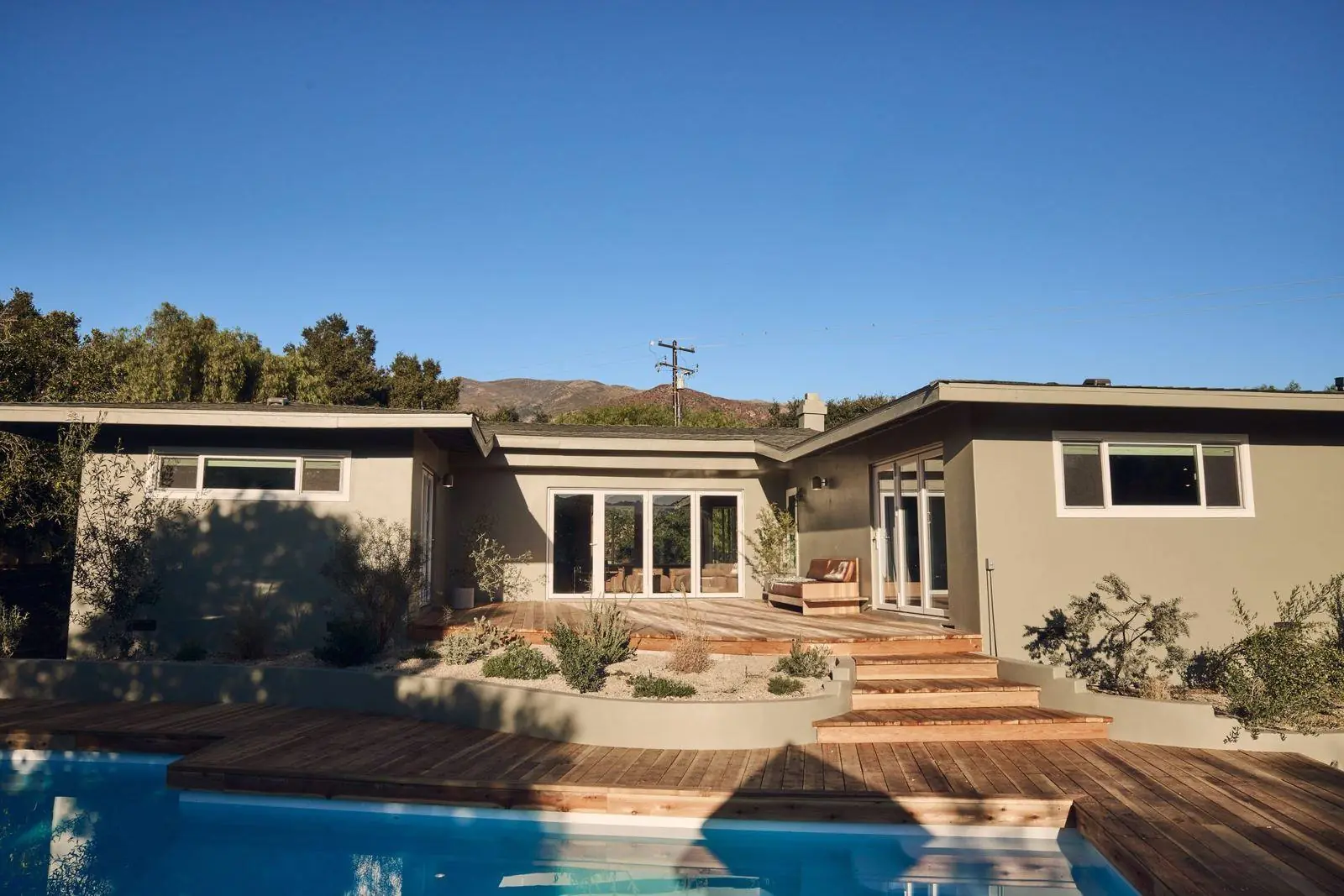 Ojai East End: a restored ranch house seen across the pool at dusk