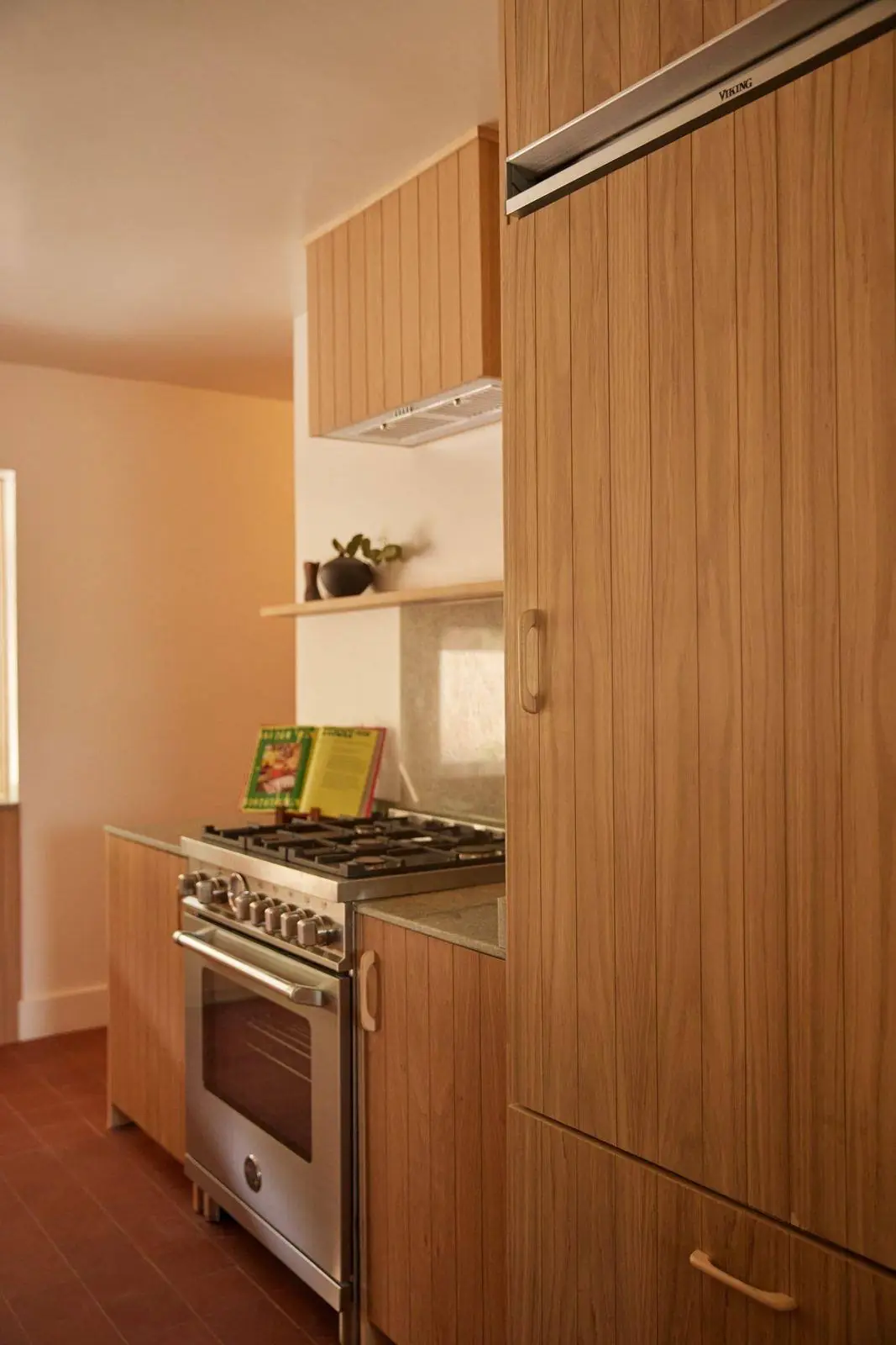 White oak slab cabinets around a range, the same oak on every face