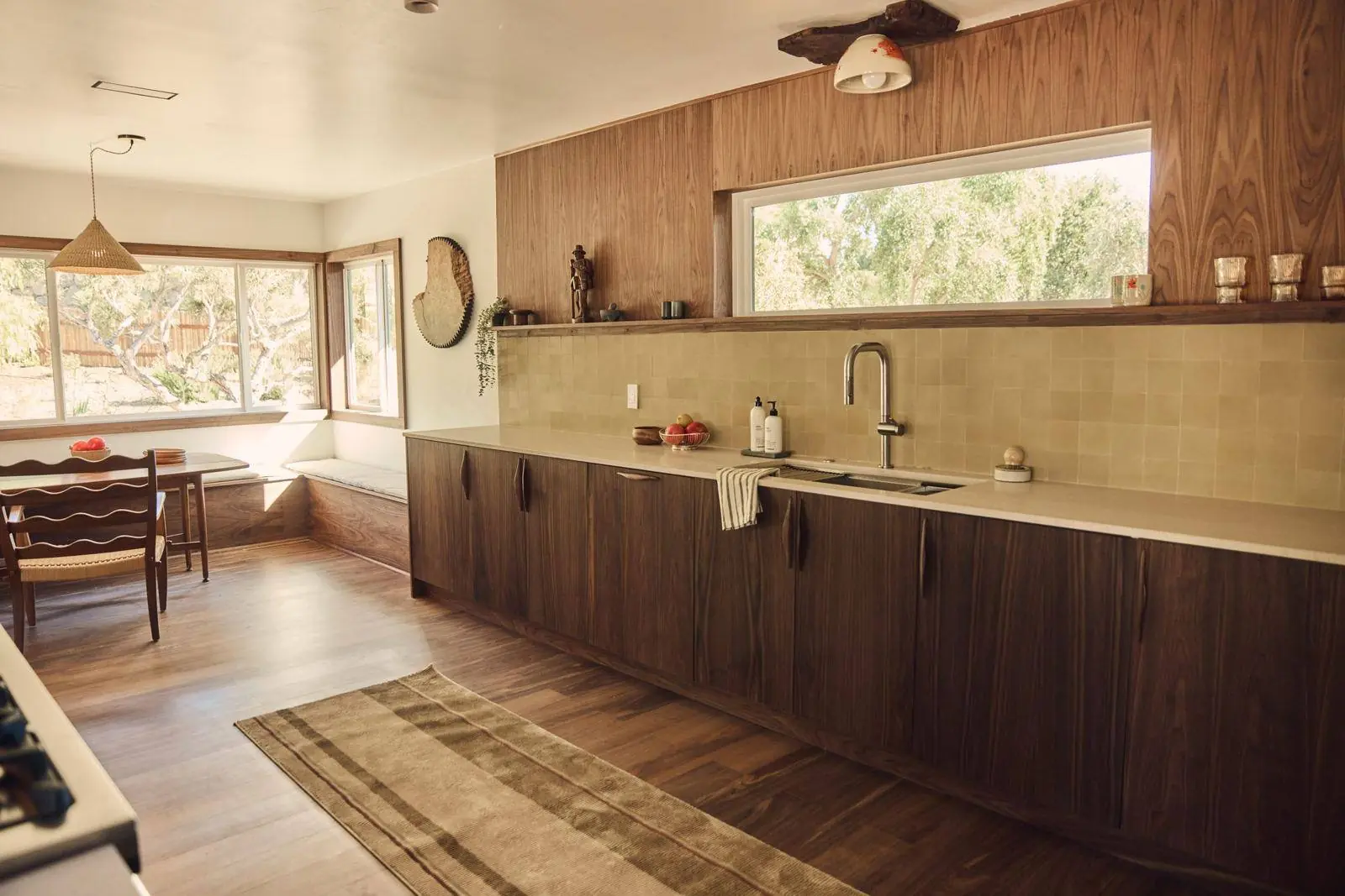 A long run of walnut slab-front cabinets under a ribbon window